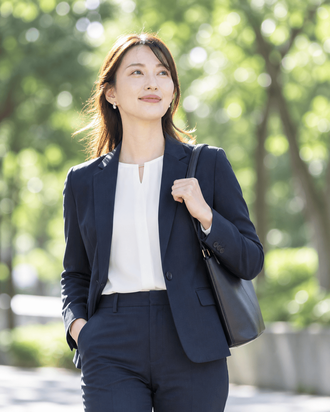 自然光の中でネイビーのスーツを着た女性